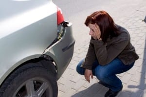 Woman Looking at Her Damaged Car